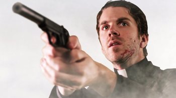 Movie still from “Father's Day” (2011), directed by Conor Sweeney – A man holding a gun in his right hand; Close Up shot, Low angle
