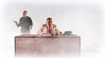 Movie still from “Father's Day” (2011), directed by Conor Sweeney – A man sitting at a desk in front of another man; Medium shot, Low angle