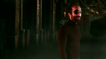 Movie still from “Father's Day” (2011), directed by Conor Sweeney – A man wearing a black shirt and a pirate eye patch; Medium shot, Low angle