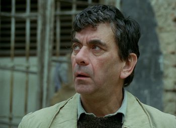 Movie still from “Faust” (1994), directed by Jan Svankmajer – A person wearing a jacket; Close Up shot, High angle