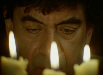 Movie still from “Faust” (1994), directed by Jan Svankmajer – A person looking at a lit candle; Extreme Close Up shot, Low angle
