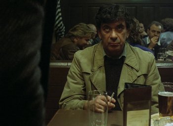 Movie still from “Faust” (1994), directed by Jan Svankmajer – A man sitting at a table in front of a glass of water; Medium shot, Over the shoulder angle