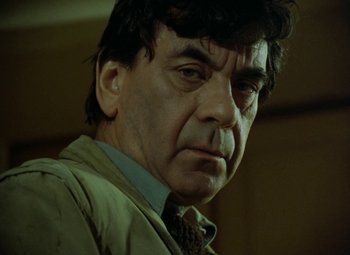 Movie still from “Faust” (1994), directed by Jan Svankmajer – A person wearing a suit and tie; Close Up shot, Low angle