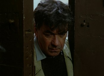 Movie still from “Faust” (1994), directed by Jan Svankmajer – A person standing near a door; Close Up shot, Low angle