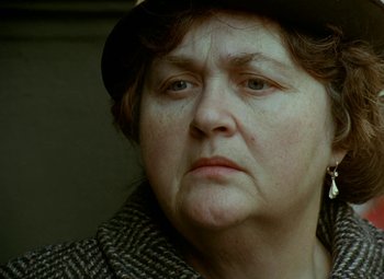 Movie still from “Faust” (1994), directed by Jan Svankmajer – An older woman wearing a hat and a jacket; Close Up shot, Low angle