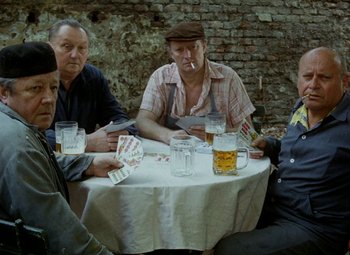 Movie still from “Faust” (1994), directed by Jan Svankmajer – A group of men sitting at a table playing cards; Medium shot, High angle
