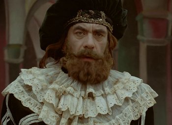 Movie still from “Faust” (1994), directed by Jan Svankmajer – A man with a beard and a crown on; Close Up shot, Low angle