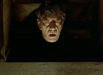Movie still from “Faust” (1994), directed by Jan Svankmajer – A man's head is shown in a dark room; Close Up shot, Low angle