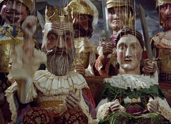 Movie still from “Faust” (1994), directed by Jan Svankmajer – A group of people dressed up like kings and queens; Wide shot, Overhead angle