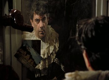 Movie still from “Faust” (1994), directed by Jan Svankmajer – A man is looking in the mirror while brushing his hair; Close Up shot, Over the shoulder angle