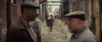 Movie still from “Fences” (2016), directed by Denzel Washington – Two older men are walking down the street; Close Up shot, Over the shoulder angle
