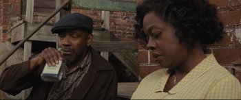 Movie still from “Fences” (2016), directed by Denzel Washington – A man and a woman sitting next to each other on a bench; Close Up shot, Low angle