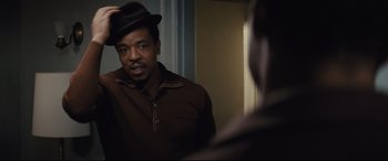 Movie still from “Fences” (2016), directed by Denzel Washington – A man wearing a hat looking into a mirror; Close Up shot, Over the shoulder angle