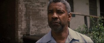 Movie still from “Fences” (2016), directed by Denzel Washington – An older black man with a gray beard looking at the camera; Close Up shot, Low angle