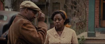 Movie still from “Fences” (2016), directed by Denzel Washington – A man and a woman standing next to each other in front of a building; Medium shot, Over the shoulder angle
