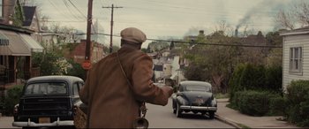 Movie still from “Fences” (2016), directed by Denzel Washington – An older man is riding down the street; Wide shot, Over the shoulder angle