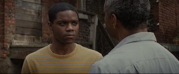 Movie still from “Fences” (2016), directed by Denzel Washington – Two men standing next to each other on a street; Close Up shot, Over the shoulder angle