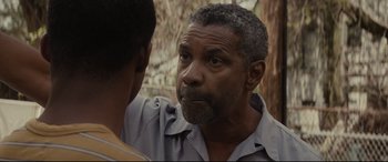 Movie still from “Fences” (2016), directed by Denzel Washington – A man is talking to another man in a forest; Close Up shot, Over the shoulder angle