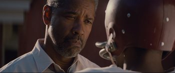 Movie still from “Fences” (2016), directed by Denzel Washington – An older black man looking at the ear of another black man; Close Up shot, Over the shoulder angle