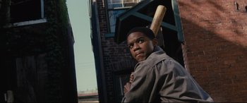 Movie still from “Fences” (2016), directed by Denzel Washington – A young man holding a baseball bat in his hands; Close Up shot, Over the shoulder angle