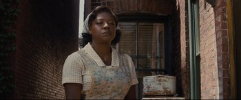 Movie still from “Fences” (2016), directed by Denzel Washington – An african american woman wearing an apron and head scarf; Medium shot, Low angle