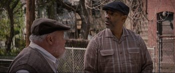 Movie still from “Fences” (2016), directed by Denzel Washington – Two older men are standing outside talking to each other; Medium shot, Over the shoulder angle