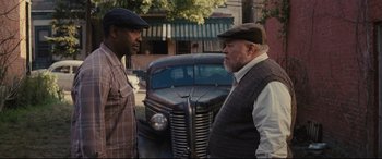 Movie still from “Fences” (2016), directed by Denzel Washington – Two men standing in front of an old truck; Medium shot, Over the shoulder angle