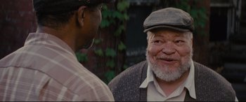 Movie still from “Fences” (2016), directed by Denzel Washington – Two men talking to each other in front of a building; Close Up shot, Over the shoulder angle