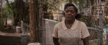 Movie still from “Fences” (2016), directed by Denzel Washington – An older black woman standing in front of a fence; Close Up shot, Over the shoulder angle