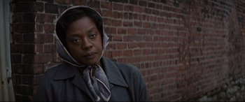 Movie still from “Fences” (2016), directed by Denzel Washington – An older woman wearing a gray coat with a scarf around her neck; Close Up shot, Low angle