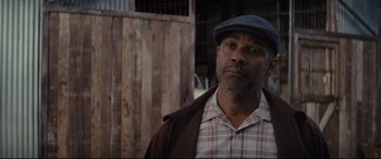 Movie still from “Fences” (2016), directed by Denzel Washington – A man wearing a hat and a plaid shirt; Close Up shot, Over the shoulder angle