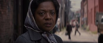 Movie still from “Fences” (2016), directed by Denzel Washington – An older woman wearing a head scarf on the street; Close Up shot, Low angle