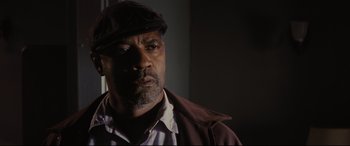 Movie still from “Fences” (2016), directed by Denzel Washington – A man in a hat and jacket looking to his left; Close Up shot, Low angle