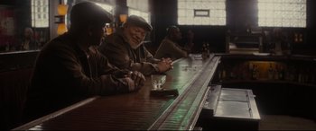 Movie still from “Fences” (2016), directed by Denzel Washington – A group of people sitting at a bar; Medium shot, Over the shoulder angle