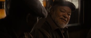 Movie still from “Fences” (2016), directed by Denzel Washington – An older man wearing a hat and a brown jacket; Close Up shot, Over the shoulder angle