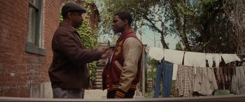 Movie still from “Fences” (2016), directed by Denzel Washington – Two men standing next to each other on a dirt road; Medium shot, Over the shoulder angle