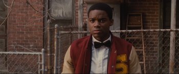 Movie still from “Fences” (2016), directed by Denzel Washington – A young man wearing a letterman jacket and bow tie; Close Up shot, Over the shoulder angle