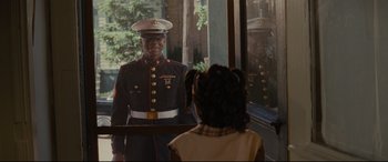 Movie still from “Fences” (2016), directed by Denzel Washington – A man in uniform standing in front of a mirror; Medium shot, Over the shoulder angle