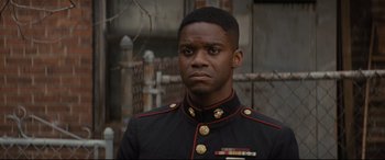 Movie still from “Fences” (2016), directed by Denzel Washington – A man in a military uniform stands in front of a building; Close Up shot, Over the shoulder angle
