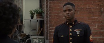 Movie still from “Fences” (2016), directed by Denzel Washington – A man in a military uniform standing in front of a brick wall; Close Up shot, Over the shoulder angle