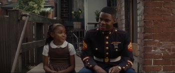 Movie still from “Fences” (2016), directed by Denzel Washington – A man in uniform sitting next to a young girl; Medium shot, Over the shoulder angle