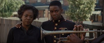 Movie still from “Fences” (2016), directed by Denzel Washington – A man in a military uniform holding a trumpet; Close Up shot, Over the shoulder angle