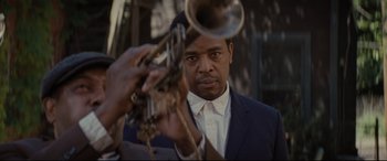 Movie still from “Fences” (2016), directed by Denzel Washington – A man in a blue suit holding a trumpet; Close Up shot, Low angle