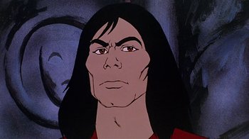 Movie still from “Fire and Ice” (1983), directed by Ralph Bakshi – A man with long black hair and a red shirt; Close Up shot, Low angle