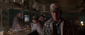 Movie still from “Fire in the Sky” (1993), directed by Robert Lieberman – A group of people sitting at a bar; Close Up shot, Over the shoulder angle