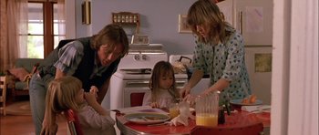 Movie still from “Fire in the Sky” (1993), directed by Robert Lieberman – A woman and two children are at a table with a plate; Medium shot, Low angle