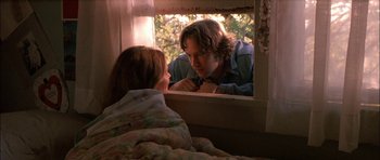 Movie still from “Fire in the Sky” (1993), directed by Robert Lieberman – A man and a woman looking at each other in a mirror; Medium shot, Low angle