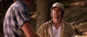 Movie still from “Fire in the Sky” (1993), directed by Robert Lieberman – A man wearing a hat standing next to another man; Close Up shot, Low angle