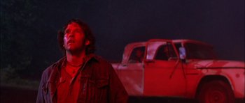 Movie still from “Fire in the Sky” (1993), directed by Robert Lieberman – A man standing in front of an old truck; Close Up shot, Low angle