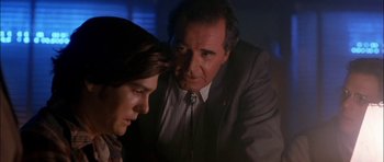 Movie still from “Fire in the Sky” (1993), directed by Robert Lieberman – An older man and a young man in a dark room; Close Up shot, Over the shoulder angle